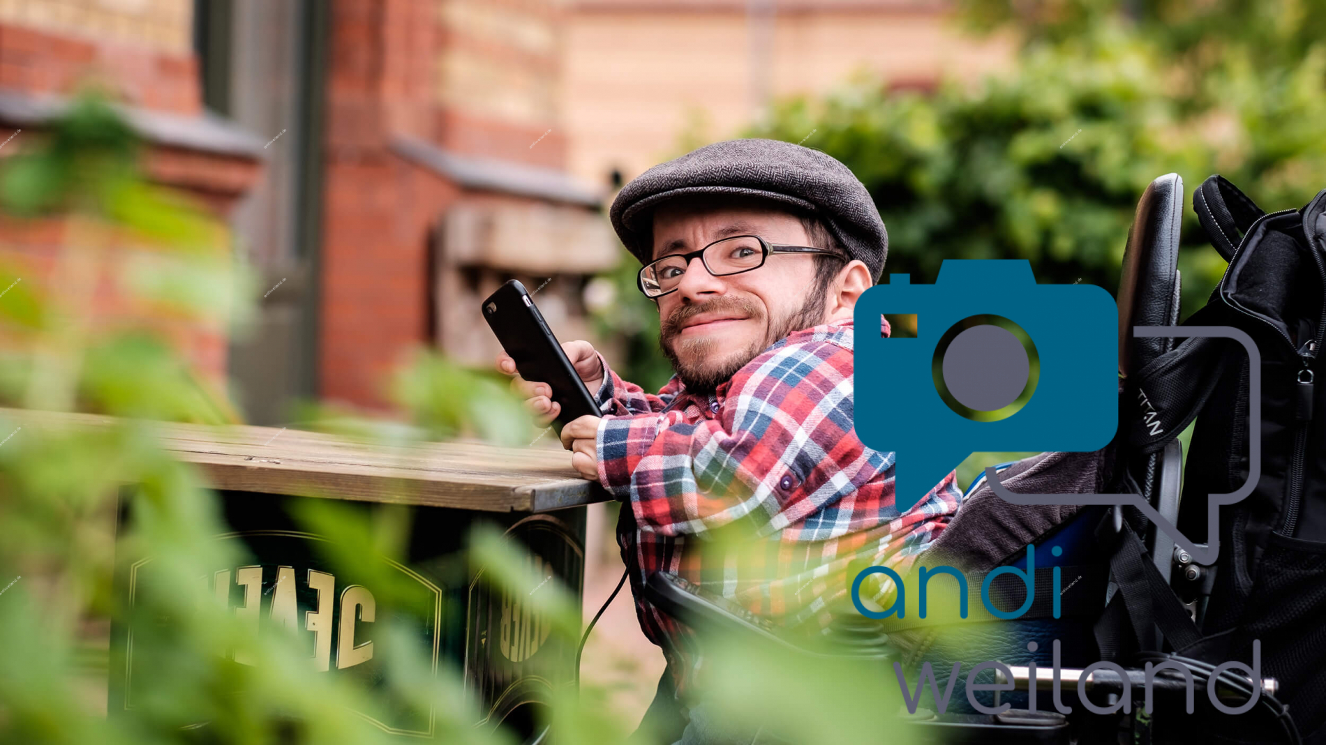 Portrait von einem vollbärtigen Mann mit kurzen Haaren, der in die Kamera lächelt. Er trägt ein Shirt mit einem Fahrrad.