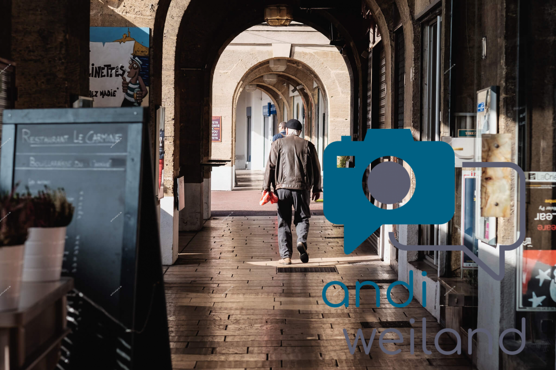 Portrait von einem vollbärtigen Mann mit kurzen Haaren, der in die Kamera lächelt. Er trägt ein Shirt mit einem Fahrrad.