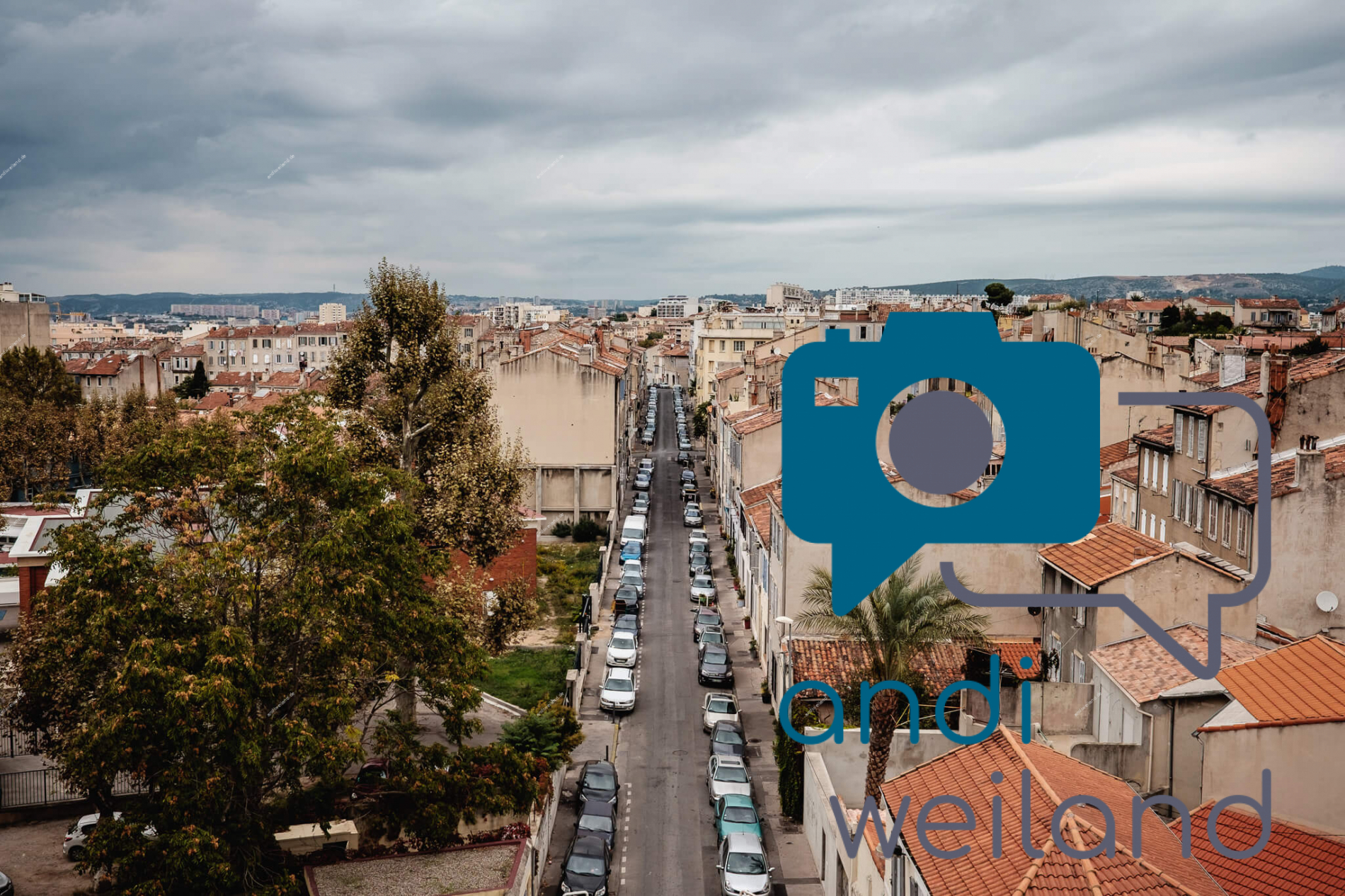 Portrait von einem vollbärtigen Mann mit kurzen Haaren, der in die Kamera lächelt. Er trägt ein Shirt mit einem Fahrrad.