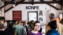 Ein Bild von einer Gruppe von Menschen Portrait von einem vollbärtigen Mann mit kurzen Haaren, der in die Kamera lächelt. Er trägt ein Shirt mit einem Fahrrad.