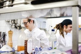 Portrait von einem vollbärtigen Mann mit kurzen Haaren, der in die Kamera lächelt. Er trägt ein Shirt mit einem Fahrrad.