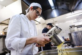 Portrait von einem vollbärtigen Mann mit kurzen Haaren, der in die Kamera lächelt. Er trägt ein Shirt mit einem Fahrrad.