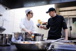 Portrait von einem vollbärtigen Mann mit kurzen Haaren, der in die Kamera lächelt. Er trägt ein Shirt mit einem Fahrrad.
