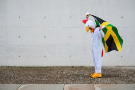 Portrait von einem vollbärtigen Mann mit kurzen Haaren, der in die Kamera lächelt. Er trägt ein Shirt mit einem Fahrrad.