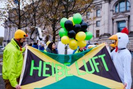 Portrait von einem vollbärtigen Mann mit kurzen Haaren, der in die Kamera lächelt. Er trägt ein Shirt mit einem Fahrrad.