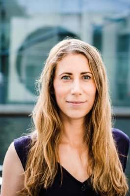 Portrait von einem vollbärtigen Mann mit kurzen Haaren, der in die Kamera lächelt. Er trägt ein Shirt mit einem Fahrrad.