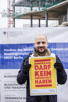  Portrait von einem vollbärtigen Mann mit kurzen Haaren, der in die Kamera lächelt. Er trägt ein Shirt mit einem Fahrrad.