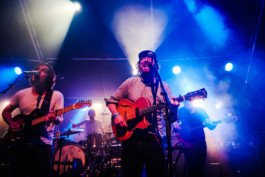 Portrait von einem vollbärtigen Mann mit kurzen Haaren, der in die Kamera lächelt. Er trägt ein Shirt mit einem Fahrrad.