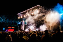 Portrait von einem vollbärtigen Mann mit kurzen Haaren, der in die Kamera lächelt. Er trägt ein Shirt mit einem Fahrrad.