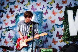 Portrait von einem vollbärtigen Mann mit kurzen Haaren, der in die Kamera lächelt. Er trägt ein Shirt mit einem Fahrrad.