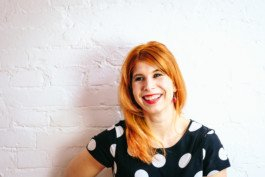 Portrait von einem vollbärtigen Mann mit kurzen Haaren, der in die Kamera lächelt. Er trägt ein Shirt mit einem Fahrrad.