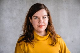 Portrait von einem vollbärtigen Mann mit kurzen Haaren, der in die Kamera lächelt. Er trägt ein Shirt mit einem Fahrrad.