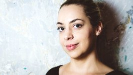 Portrait von einem vollbärtigen Mann mit kurzen Haaren, der in die Kamera lächelt. Er trägt ein Shirt mit einem Fahrrad.