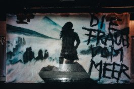 Portrait von einem vollbärtigen Mann mit kurzen Haaren, der in die Kamera lächelt. Er trägt ein Shirt mit einem Fahrrad.