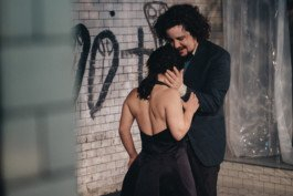 Portrait von einem vollbärtigen Mann mit kurzen Haaren, der in die Kamera lächelt. Er trägt ein Shirt mit einem Fahrrad.