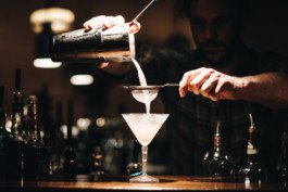 Portrait von einem vollbärtigen Mann mit kurzen Haaren, der in die Kamera lächelt. Er trägt ein Shirt mit einem Fahrrad.