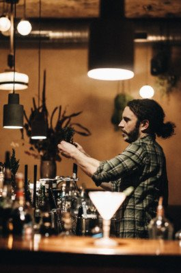 Portrait von einem vollbärtigen Mann mit kurzen Haaren, der in die Kamera lächelt. Er trägt ein Shirt mit einem Fahrrad.