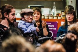 Portrait von einem vollbärtigen Mann mit kurzen Haaren, der in die Kamera lächelt. Er trägt ein Shirt mit einem Fahrrad.