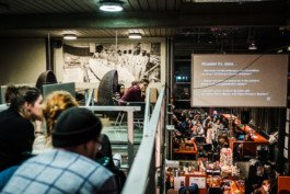 Portrait von einem vollbärtigen Mann mit kurzen Haaren, der in die Kamera lächelt. Er trägt ein Shirt mit einem Fahrrad.