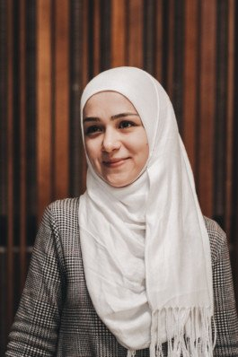 Portrait von einem vollbärtigen Mann mit kurzen Haaren, der in die Kamera lächelt. Er trägt ein Shirt mit einem Fahrrad.