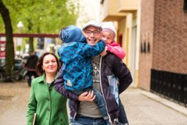 Portrait von einem vollbärtigen Mann mit kurzen Haaren, der in die Kamera lächelt. Er trägt ein Shirt mit einem Fahrrad.
