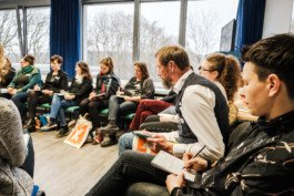  Portrait von einem vollbärtigen Mann mit kurzen Haaren, der in die Kamera lächelt. Er trägt ein Shirt mit einem Fahrrad.