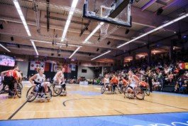 Portrait von einem vollbärtigen Mann mit kurzen Haaren, der in die Kamera lächelt. Er trägt ein Shirt mit einem Fahrrad.