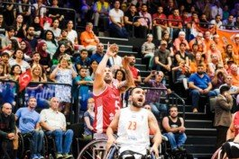 Portrait von einem vollbärtigen Mann mit kurzen Haaren, der in die Kamera lächelt. Er trägt ein Shirt mit einem Fahrrad.
