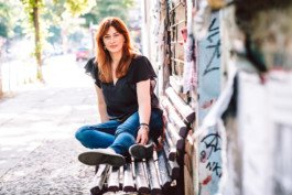 Portrait von einem vollbärtigen Mann mit kurzen Haaren, der in die Kamera lächelt. Er trägt ein Shirt mit einem Fahrrad.