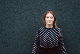 Portrait von einem vollbärtigen Mann mit kurzen Haaren, der in die Kamera lächelt. Er trägt ein Shirt mit einem Fahrrad.