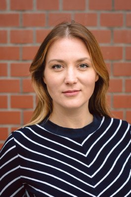 Portrait von einem vollbärtigen Mann mit kurzen Haaren, der in die Kamera lächelt. Er trägt ein Shirt mit einem Fahrrad.