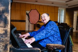 Portrait von einem vollbärtigen Mann mit kurzen Haaren, der in die Kamera lächelt. Er trägt ein Shirt mit einem Fahrrad.