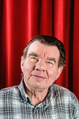 Portrait von einem vollbärtigen Mann mit kurzen Haaren, der in die Kamera lächelt. Er trägt ein Shirt mit einem Fahrrad.