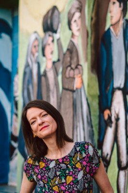 Portrait von einem vollbärtigen Mann mit kurzen Haaren, der in die Kamera lächelt. Er trägt ein Shirt mit einem Fahrrad.