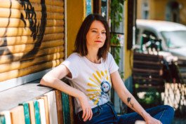 Portrait von einem vollbärtigen Mann mit kurzen Haaren, der in die Kamera lächelt. Er trägt ein Shirt mit einem Fahrrad.