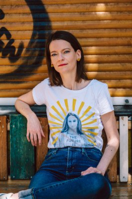 Portrait von einem vollbärtigen Mann mit kurzen Haaren, der in die Kamera lächelt. Er trägt ein Shirt mit einem Fahrrad.