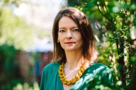 Portrait von einem vollbärtigen Mann mit kurzen Haaren, der in die Kamera lächelt. Er trägt ein Shirt mit einem Fahrrad.