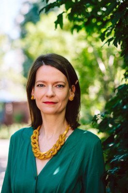 Portrait von einem vollbärtigen Mann mit kurzen Haaren, der in die Kamera lächelt. Er trägt ein Shirt mit einem Fahrrad.