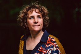 Portrait von einem vollbärtigen Mann mit kurzen Haaren, der in die Kamera lächelt. Er trägt ein Shirt mit einem Fahrrad.