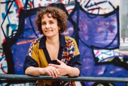 Portrait von einem vollbärtigen Mann mit kurzen Haaren, der in die Kamera lächelt. Er trägt ein Shirt mit einem Fahrrad.