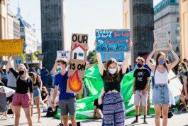 Portrait von einem vollbärtigen Mann mit kurzen Haaren, der in die Kamera lächelt. Er trägt ein Shirt mit einem Fahrrad.