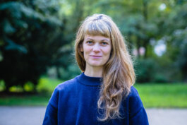 Portrait von einem vollbärtigen Mann mit kurzen Haaren, der in die Kamera lächelt. Er trägt ein Shirt mit einem Fahrrad.