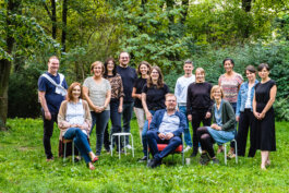 Portrait von einem vollbärtigen Mann mit kurzen Haaren, der in die Kamera lächelt. Er trägt ein Shirt mit einem Fahrrad.