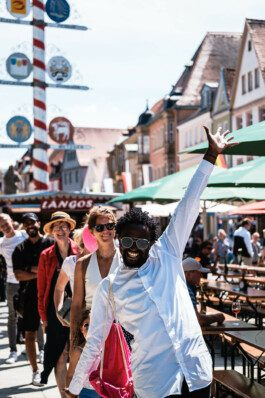 Portrait von einem vollbärtigen Mann mit kurzen Haaren, der in die Kamera lächelt. Er trägt ein Shirt mit einem Fahrrad.