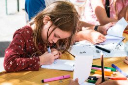 Portrait von einem vollbärtigen Mann mit kurzen Haaren, der in die Kamera lächelt. Er trägt ein Shirt mit einem Fahrrad.