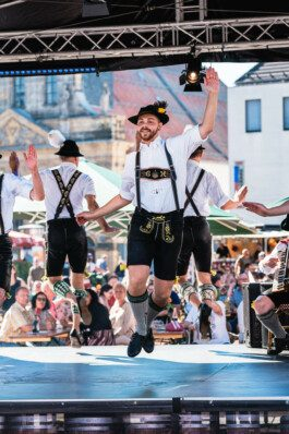 Portrait von einem vollbärtigen Mann mit kurzen Haaren, der in die Kamera lächelt. Er trägt ein Shirt mit einem Fahrrad.