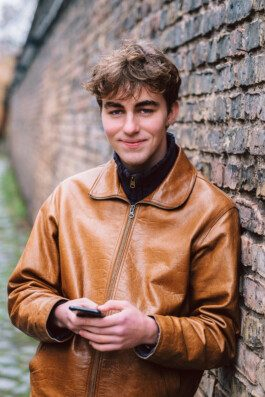 Portrait von einem vollbärtigen Mann mit kurzen Haaren, der in die Kamera lächelt. Er trägt ein Shirt mit einem Fahrrad.