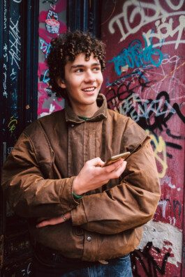 Portrait von einem vollbärtigen Mann mit kurzen Haaren, der in die Kamera lächelt. Er trägt ein Shirt mit einem Fahrrad.