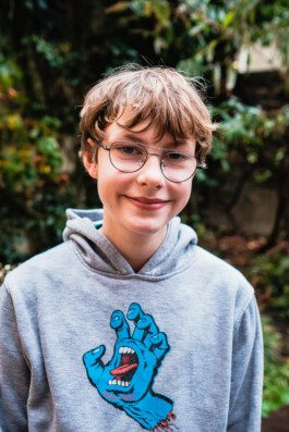 Portrait von einem vollbärtigen Mann mit kurzen Haaren, der in die Kamera lächelt. Er trägt ein Shirt mit einem Fahrrad.