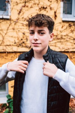 Portrait von einem vollbärtigen Mann mit kurzen Haaren, der in die Kamera lächelt. Er trägt ein Shirt mit einem Fahrrad.